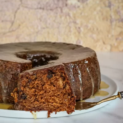 Chocolate carrot cake with glaze dripping down the sides.