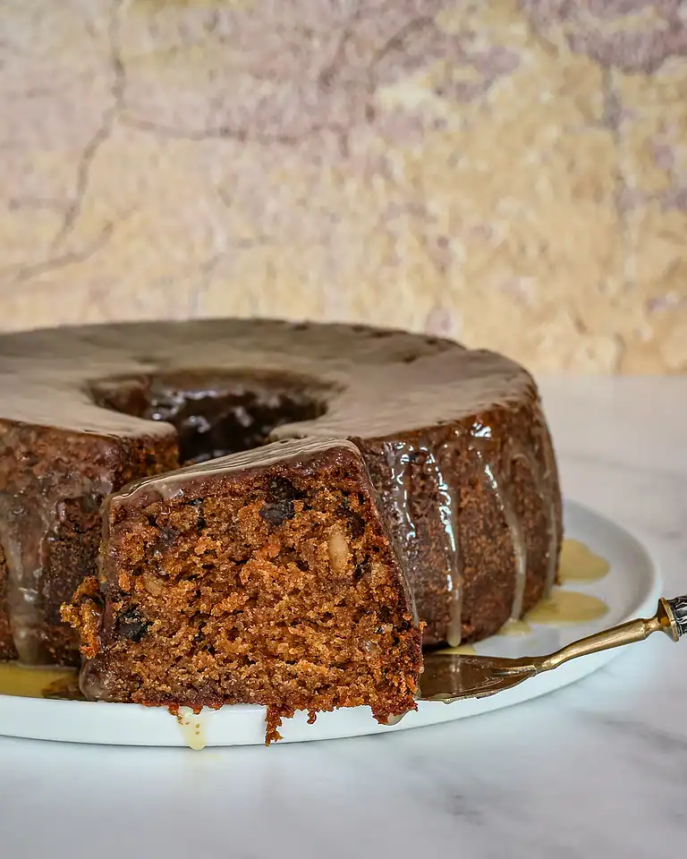 Chocolate carrot cake with glaze dripping down the sides.