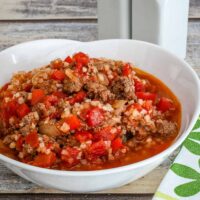 A serving bowl of caulifower Spanish rice, made with riced cauliflower, ground beef, peppers, and tomatoes.