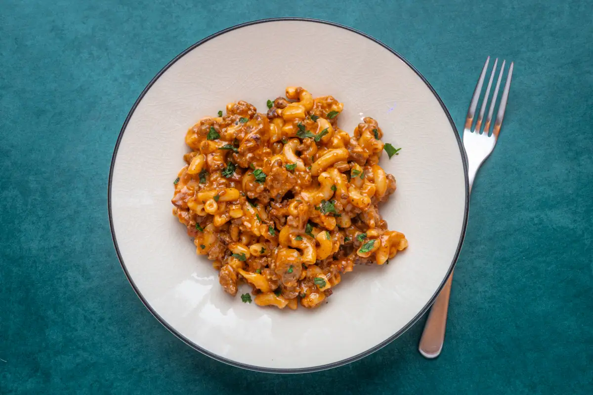 A serving of cheeseburger mac with parsley garnish.