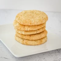 Crispy oatmeal cookies stacked on white plate.