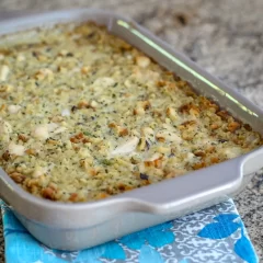 Baked casserole with a golden breadcrumb topping and herbs.