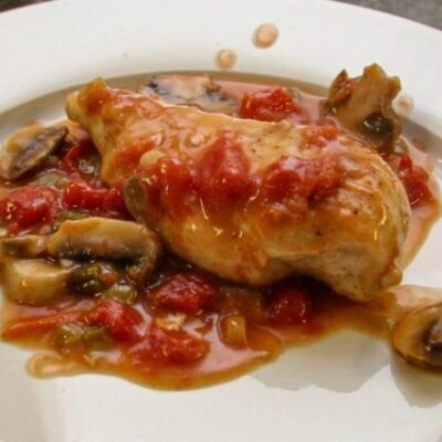 chicken breasts with tomatoes and mushrooms on a plate
