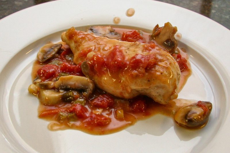 chicken breasts with tomatoes and mushrooms on a plate