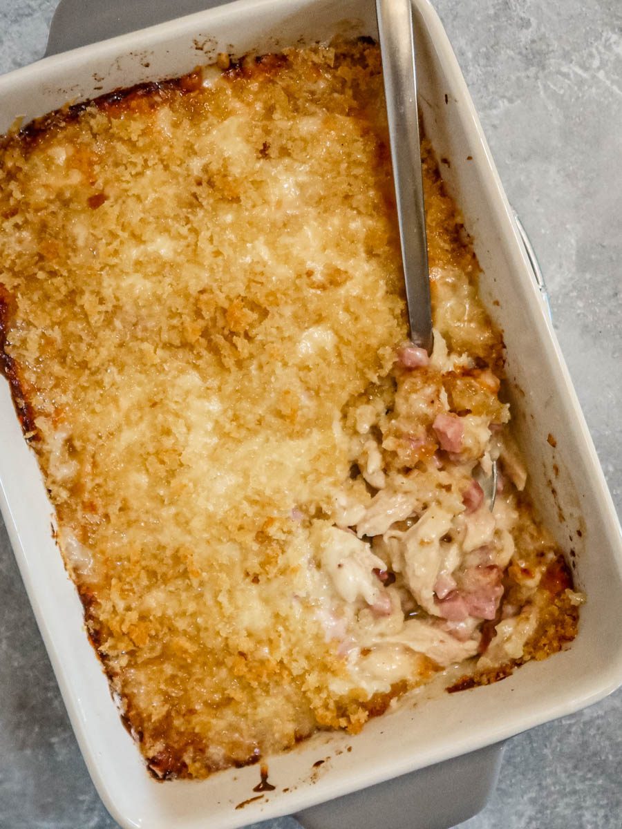 chicken cordon bleu casserole in the baking dish with spoon