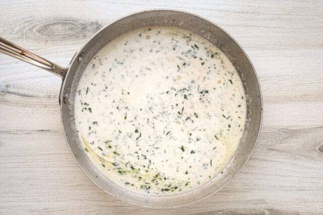 Creamy herb sauce in a skillet.