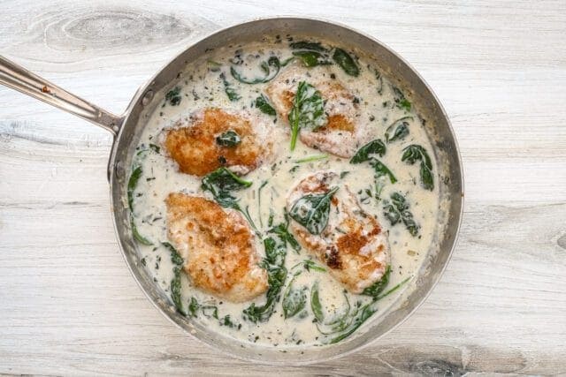 Chicken florentine in a skillet with creamy sauce, ready to serve and enjoy.