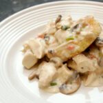 chicken and mushrooms with fried grits cakes on a plate