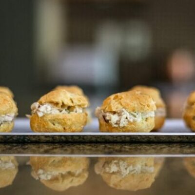 chicken salad puffs lined up on an appetizer tray