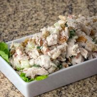 Chicken salad with bacon on lettuce leaves.