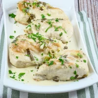 Baked chicken breasts with creamy herb sauce and chopped green onions.
