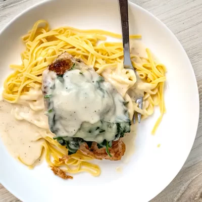 Creamy chicken and spinach stuffed on a bed of cooked spaghetti.