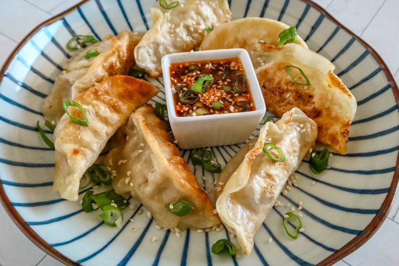another view of a plate of dumplings with chili crisp sauce in the center
