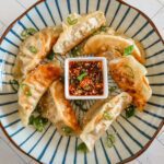 chili crisp sauce for dumplings on a plate with fried dumplings