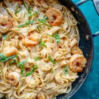 A pan of shrimp fettuccine Alfredo with chili crisp and basil.