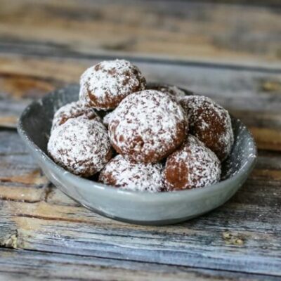 Chocolate butterball cookies in a small dish.