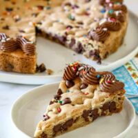 A chocolate chip cookie cake decorated with chocolate frosting and sprinkles.
