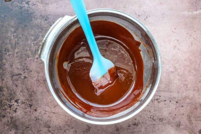 Creamy melted chocolate in a mixing bowl with a spatula.