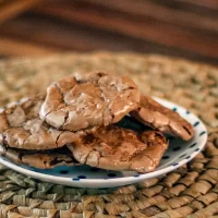 Rich chocolate chip cookies on a small dish.