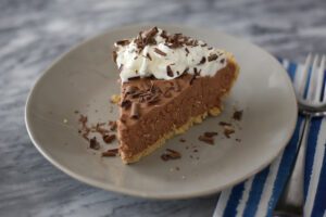 A chocolate amaretto pie garnished with whipped cream and chocolate