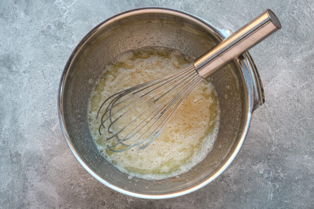 Chocolate zucchini muffin prep: combine eggs with milk, oil, and vanilla.