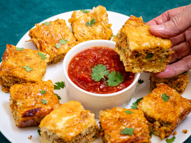 Chorizo quiche squares. on a platter with salsa and cilantro.