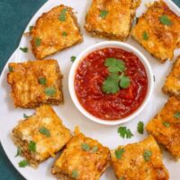 Platter of chorizo appetizer squares with salsa for dipping.