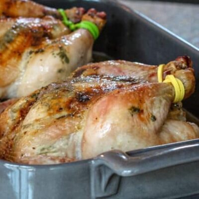 garlic and cilantro butter cornish game hens in a roasting pan
