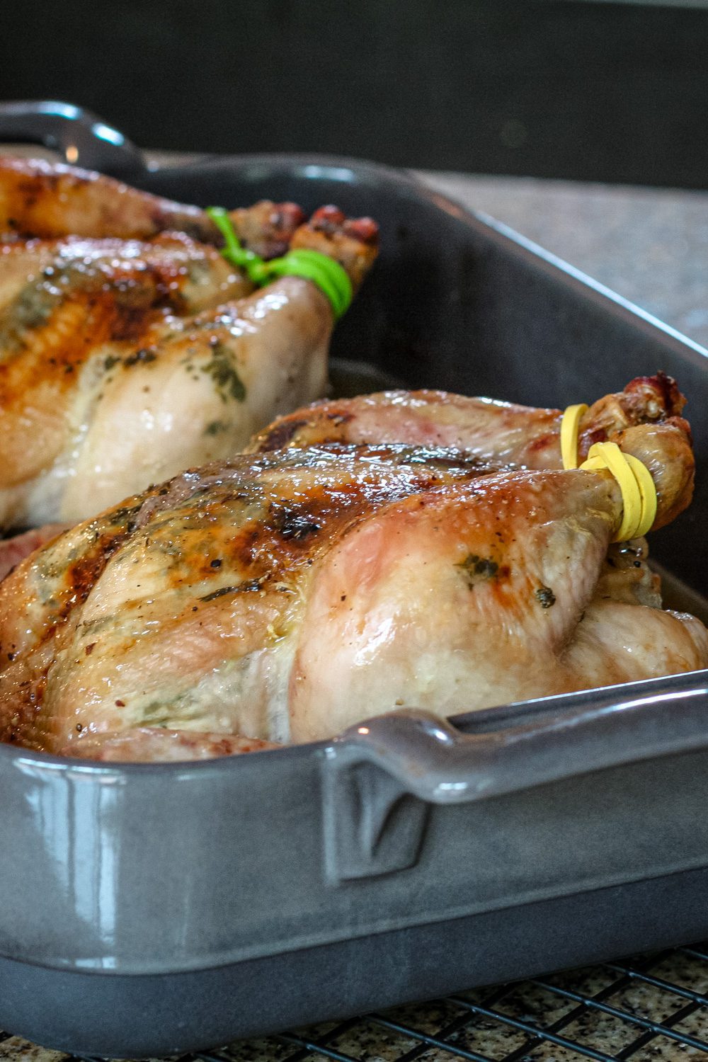 garlic and cilantro butter cornish game hens in a roasting pan