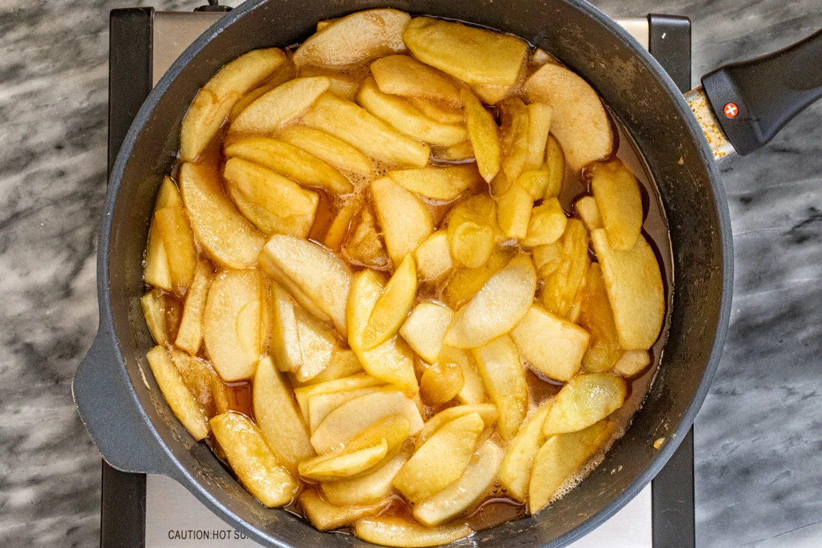 Cooking cinnamon apples in a skillet.