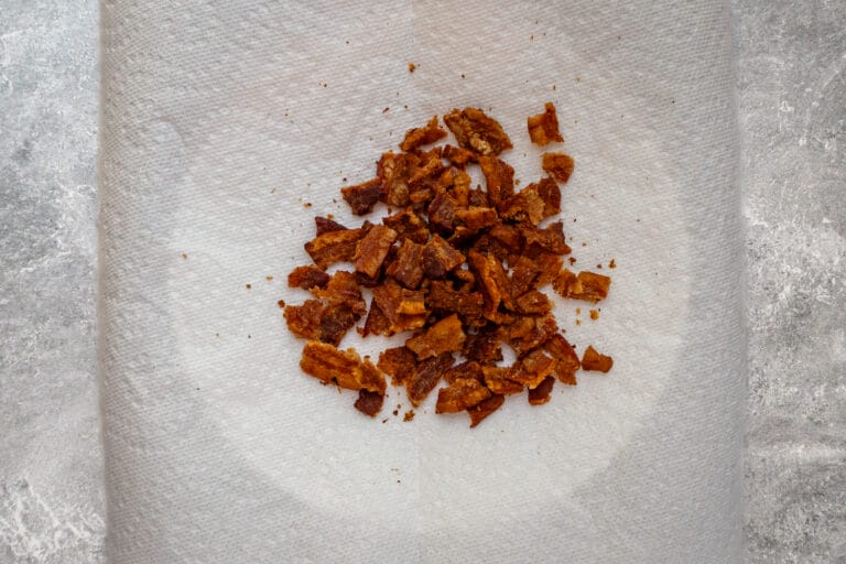Crispy cooked bacon bits on paper towel.