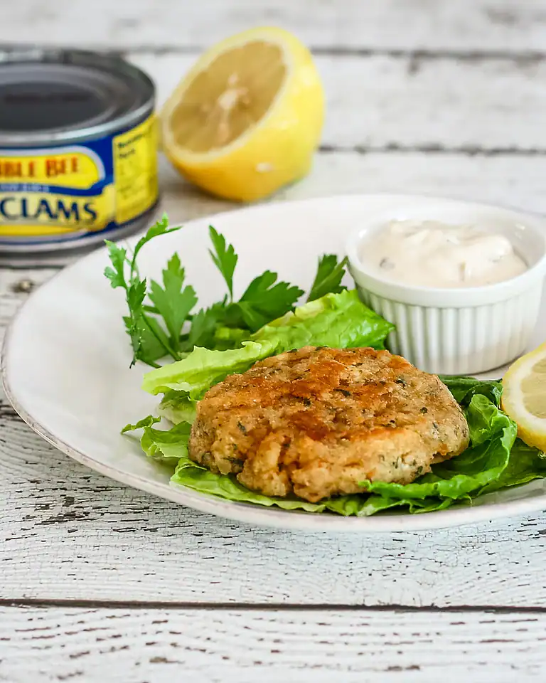 Crispy fish fillet on a bed of lettuce with lemon and tartar sauce.