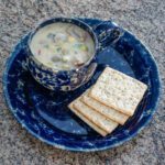 cup of clam and corn chowder with crackers