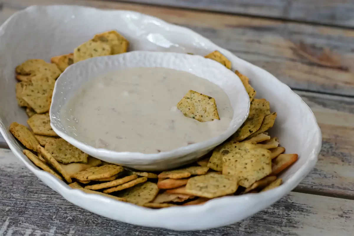 Crispy multigrain chips with creamy ranch dip on a rustic wooden table.