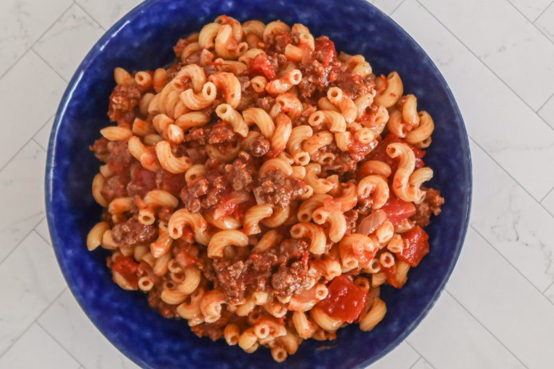 american chop suey with ground beef and tomatoes in a large serving bowl