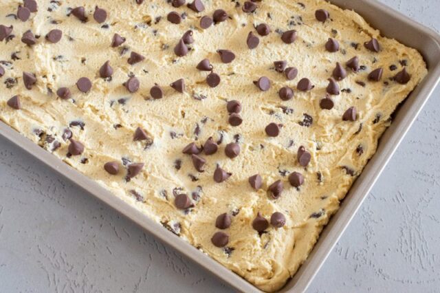 chocolate chip cookie dough is sperad in the pan