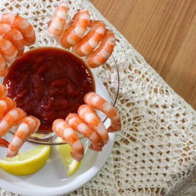 overhead shot of cocktail sauce surrounded by shrimp