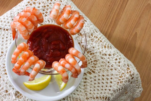 overhead shot of cocktail sauce surrounded by shrimp