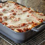 A baking dish of lasagna on a cooling rack