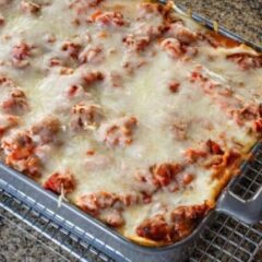 Homemade easy lasagna in a baking dish on a cooling rack.