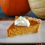 a slice of classic pumpkin pie with whipped cream