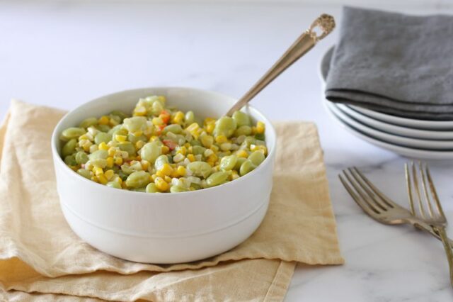 a serving bowl of succotash with corn and lima beans