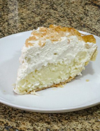 a slice of coconut cream pie with toasted coconut garnish