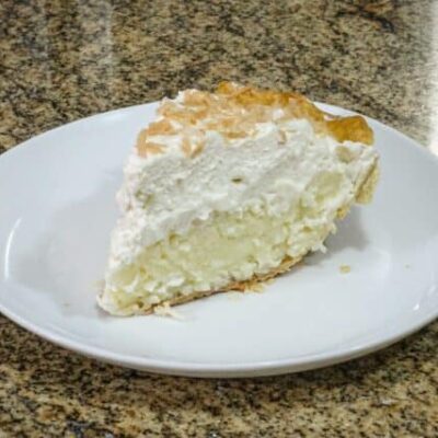 a slice of coconut cream pie with toasted coconut garnish