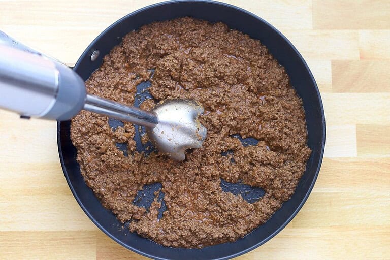 Fried ground beef in a black skillet.