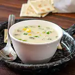Creamy corn and beef soup served in a white bowl.