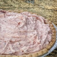 A no bake cranberry cream pie made with freshly whipped cream, orange gelatin, and cranberry sauce.