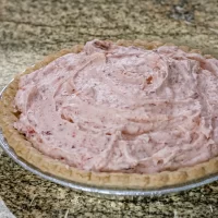 Creamy strawberry pie filling in a pie crust.