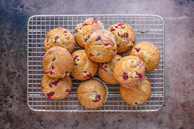 Freshly baked cranberry orange muffins on a cooling rack