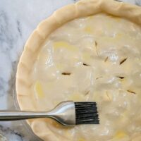 Brushing an egg wash on cream cheese pie pastry.